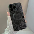 Magnetic wireless phone case in matte black with vented back pattern shown in hand under soft light.