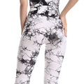 High-waisted white leggings with black marble pattern and form-fitting compression design