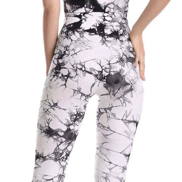 High-waisted white leggings with black marble pattern and form-fitting compression design