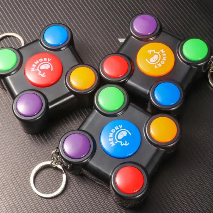 Multiple memory game units in different button color variations with attached keychains.