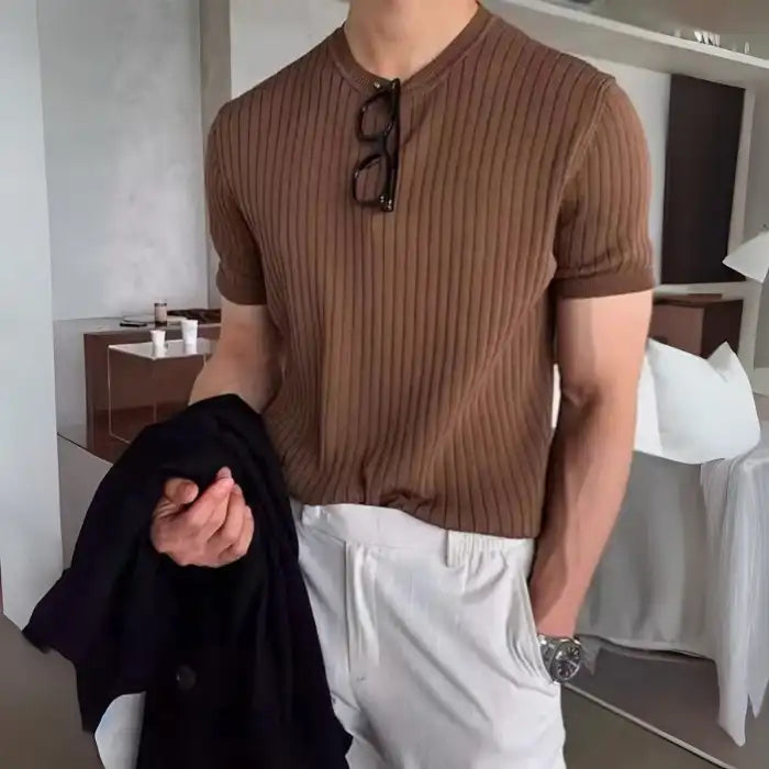 Closeup of men's plus size ribbed knit t-shirt in brown with white pants and glasses hanging on collar.
