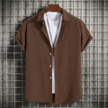 Men's plus size casual short sleeve button-up shirt in brown with white undershirt and necklace on hanger.