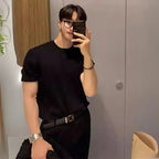 Men's plus size ribbed knit t-shirt with glasses and belt, paired with black pants and watch.