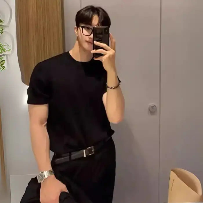 Men's plus size ribbed knit t-shirt with glasses and belt, paired with black pants and watch.