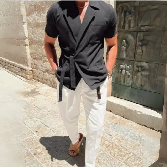 Men's plus size tied lightweight linen wrap top in black paired with white pants and sandals