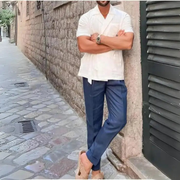 Men's plus size tied lightweight linen wrap top white worn with navy pants and arms crossed outdoors