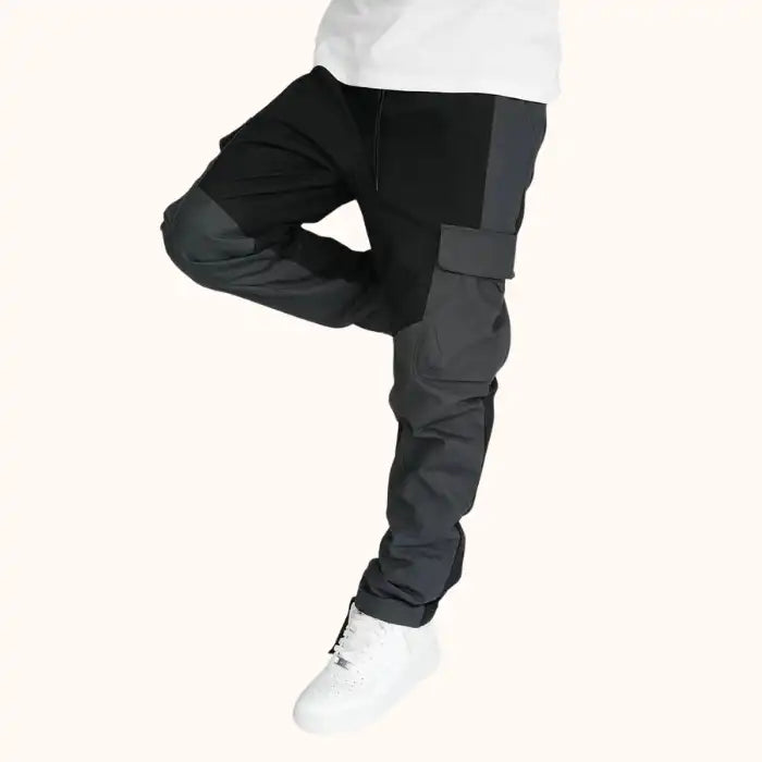 Men's dark gray and black cargo trousers paired with white sneakers, featuring side pockets
