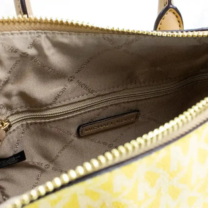 Inside view of Michael Kors yellow tote, showcasing branded fabric lining and zip pocket.