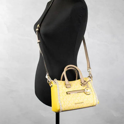 Michael Kors yellow logo tote displayed on mannequin, demonstrating adjustable strap and chic style.