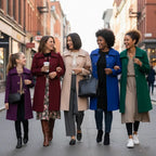 Mid length wool coat styled in multiple colors by women walking downtown, showcasing versatile fits for everyday wear.