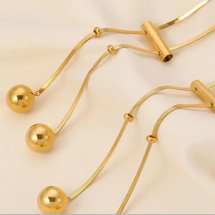 Close-up portrait showing gold pendant necklace styled with black turtleneck and coral lipstick