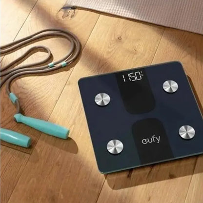 Smart scale with jump rope on wooden floor showing ultra-light, LED display and slim design features