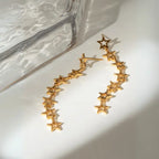 Contemporary gold star chain earrings with geometric design on white background