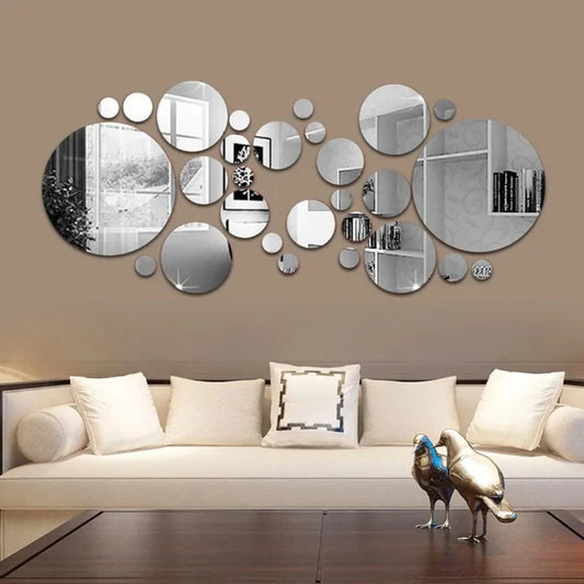 Circular mirror wall art above white sofa in modern living room, with decorative metal birds on coffee table.