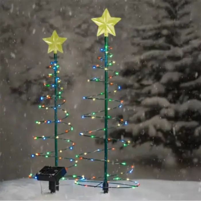 Two spiral Christmas trees with multicolored LED lights and star toppers, illuminating a snowy night scene