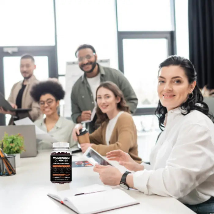 Mushroom gummies bottle on a table during a team meeting, promoting workplace wellness and energy.