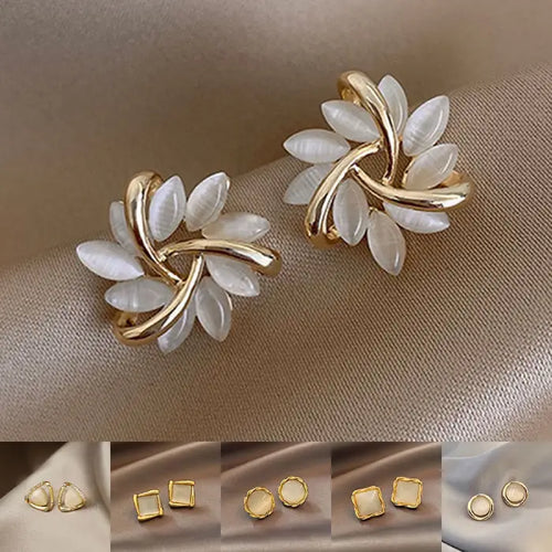 Natural white opal cat's eye earrings collection displayed on satin, showcasing multiple gold designs with soft gemstone shine