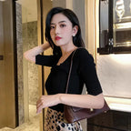 Natural white opal cat's eye earrings styled with black top and bag, showcasing their refined floral shine for modern fashion looks