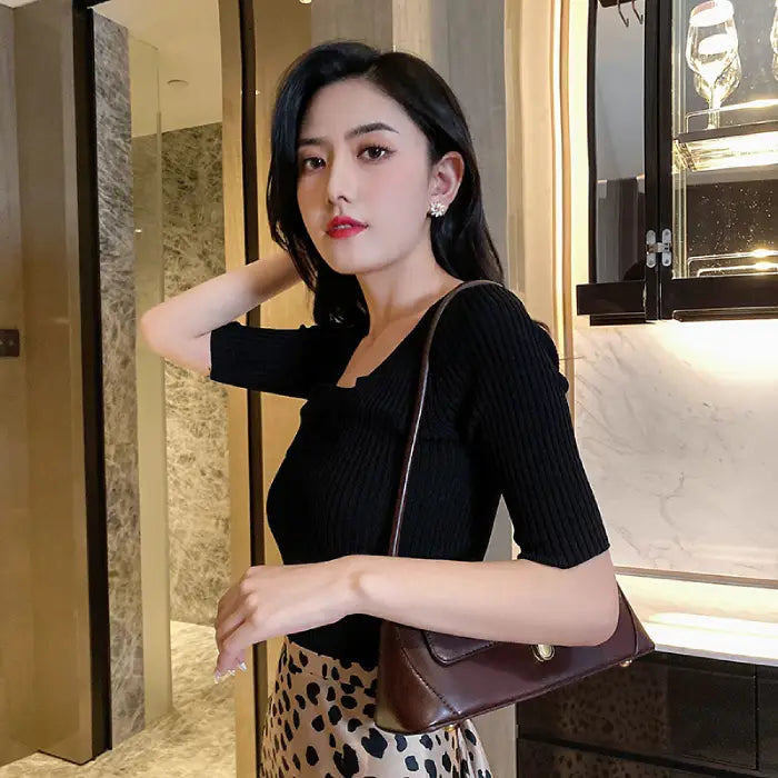 Natural white opal cat's eye earrings styled with black top and bag, showcasing their refined floral shine for modern fashion looks