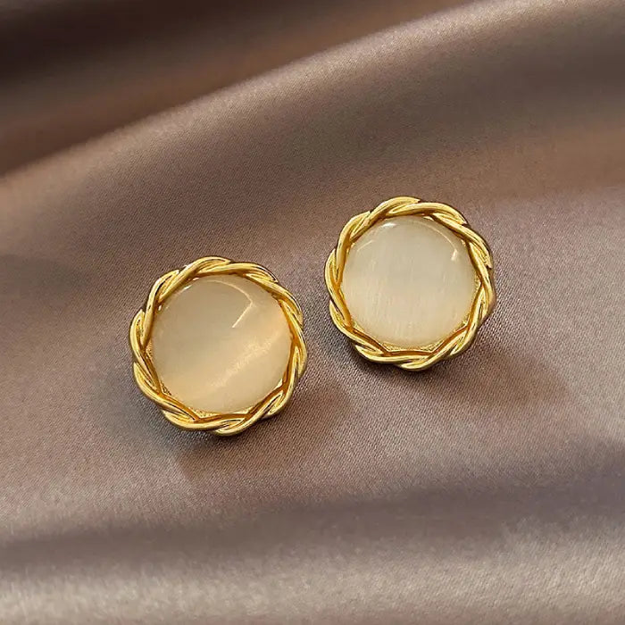Natural white opal cat's eye earrings featuring braided gold round borders, adding vintage charm and gentle gemstone glow