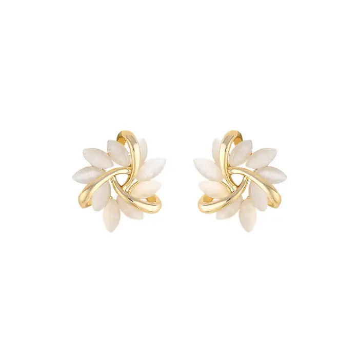 Natural white opal cat's eye earrings in gold leaf swirl motif shown on white background, delivering soft luminous elegance