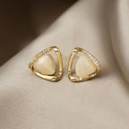Natural white opal cat's eye earrings in gold triangular setting with shimmering stones, offering a refined luminous style