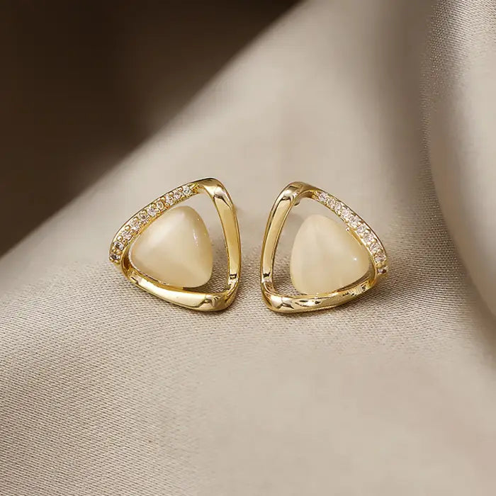 Natural white opal cat's eye earrings in gold triangular setting with shimmering stones, offering a refined luminous style