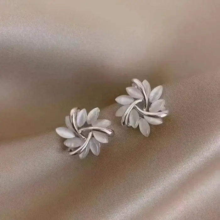 Natural white opal cat's eye earrings in silver leaf swirl design, highlighting luminous stones for delicate feminine style