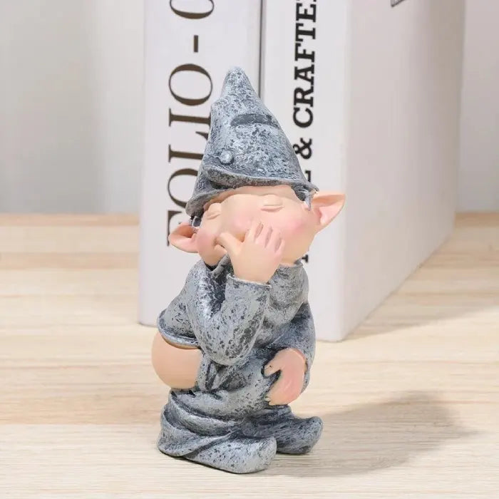 Gnome figurine with a gray outfit and hat on a light wooden surface.