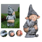 Naughty garden gnome statue with hat, crouching and mooning, holding nose in cheeky pose.