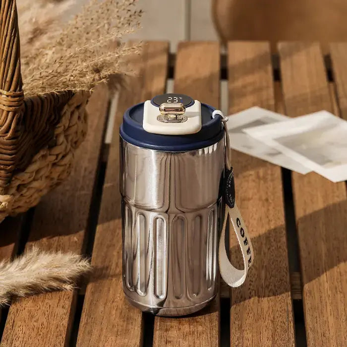 Navy blue accented smart coffee mug on wooden surface with rustic background and dried plants