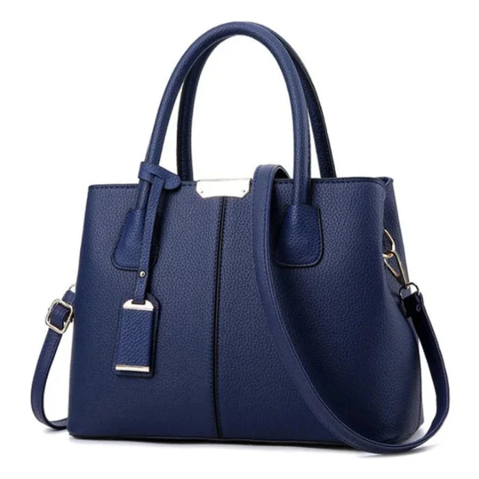 Classic navy blue leather tote bag with adjustable strap and gold accents for versatile styling.