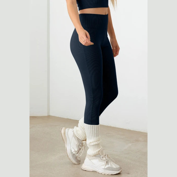 High-waisted navy blue ribbed leggings styled with chunky white leg warmers and athletic sneakers - trendy workout wear