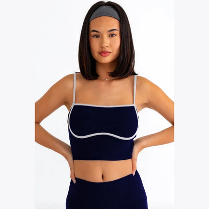 Stylish navy blue ribbed sports bra with white trim detail and adjustable straps, perfect for modern athletic wear