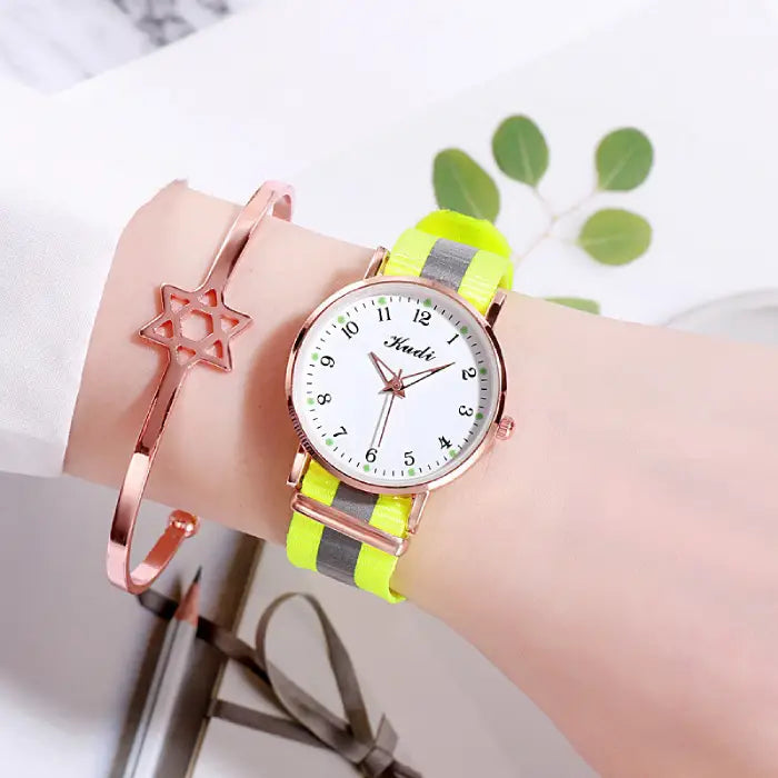 Women's watch with a white dial and neon yellow strap, complemented by a rose gold star bracelet.