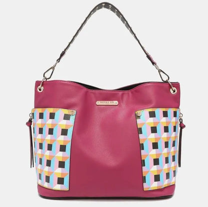 Designer pink hobo bag featuring geometric print side panels, branded metal plate, and polka dot shoulder strap