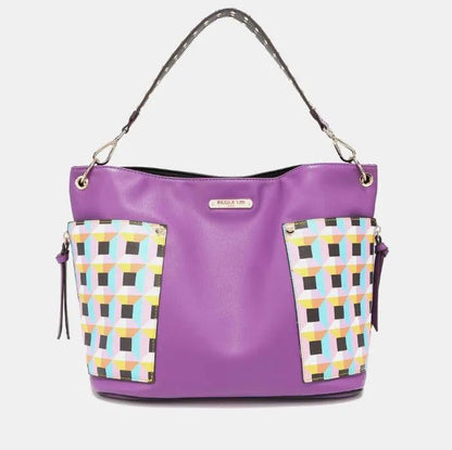 Designer purple handbag featuring geometric print panels, branded nameplate, and convertible shoulder strap