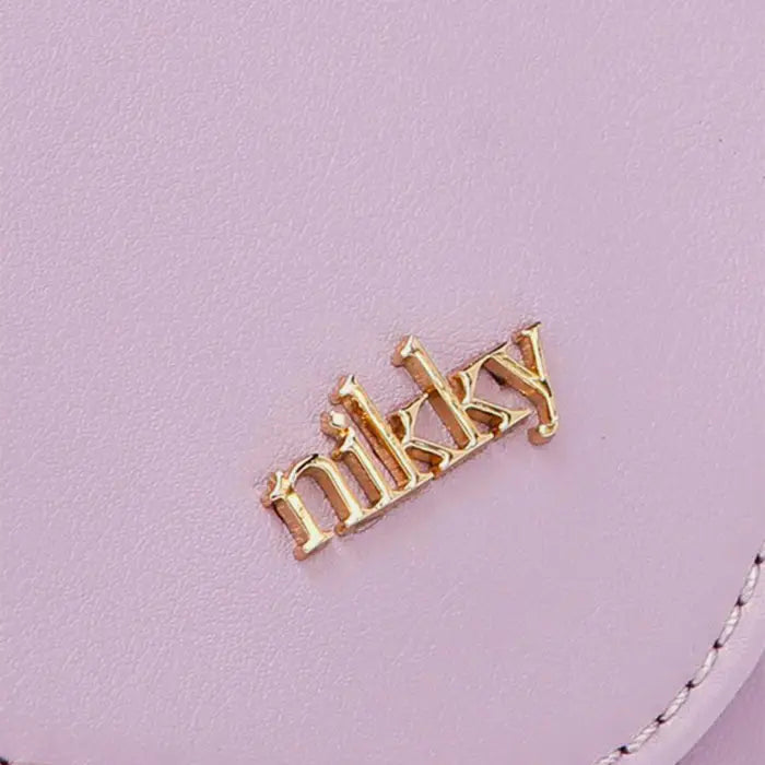 Close-up of gold Nikky brand logo embellishment on light purple leather handbag showing premium brand identity