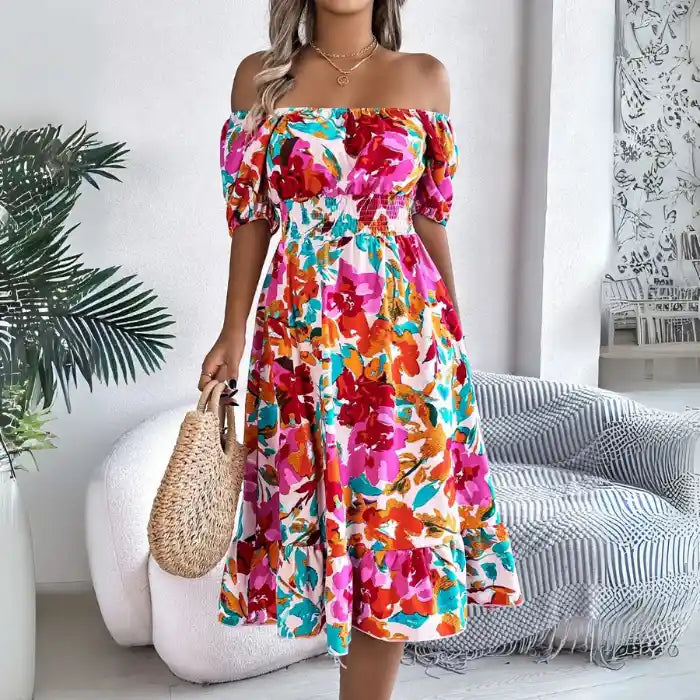 Off shoulder floral midi dress sitting down showing vibrant print and comfortable smocked fit.