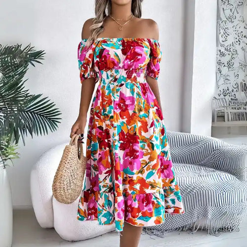 Off shoulder floral midi dress sitting down showing vibrant print and comfortable smocked fit.