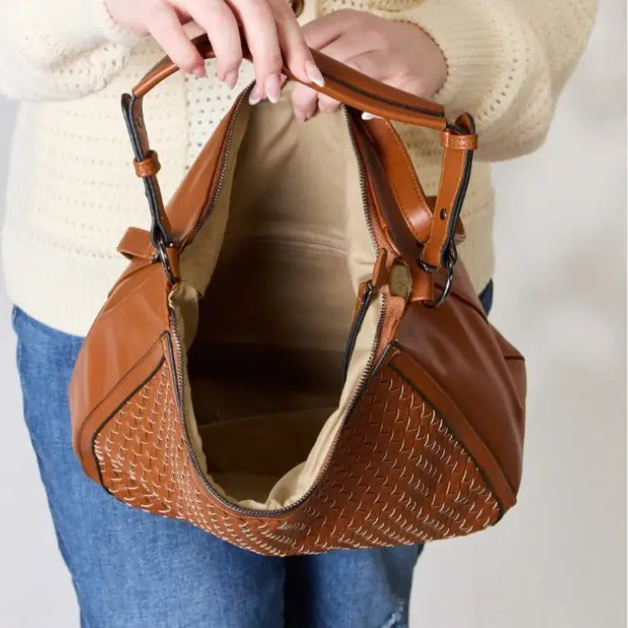 Interior view of an open brown woven leather handbag.