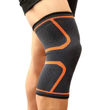 Black knee support sleeve with orange geometric pattern, worn on leg showcasing fit and design