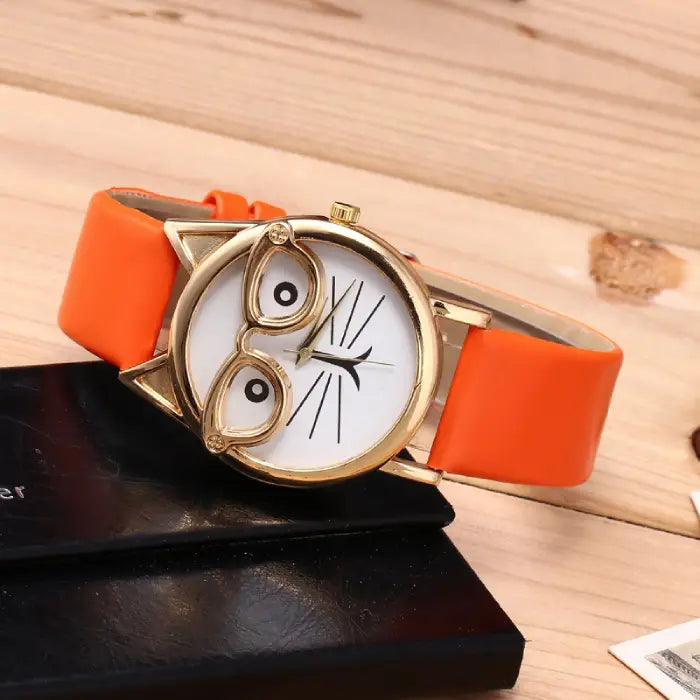 Stylish orange cat-ear wristwatch with a quirky white dial featuring a cat face design and gold accents.