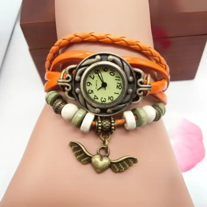 Stylish orange leather bracelet watch with vintage charm, decorative beads, and boho-chic style appeal.