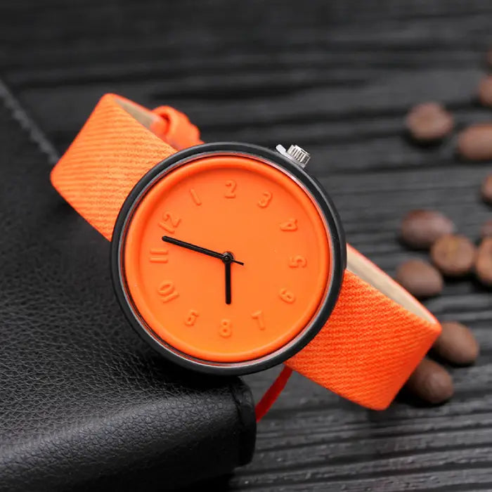 Vibrant orange minimalist wristwatch with embossed numbers and black hands for a bold fashion statement.