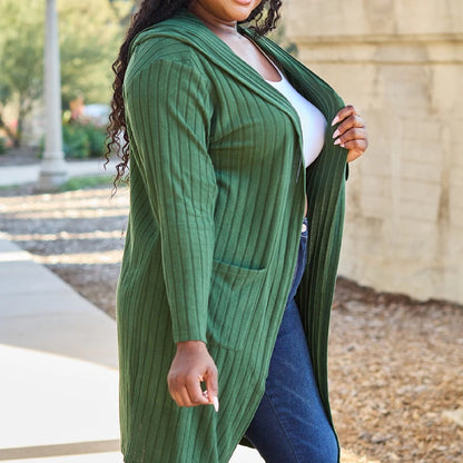 Long green ribbed cardigan styled with classic denim jeans and white top, showcasing versatile plus size fall fashion