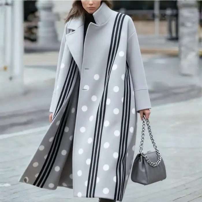 Overcoat with white polka dots and black stripes on light grey fabric, styled with silver chain handbag.