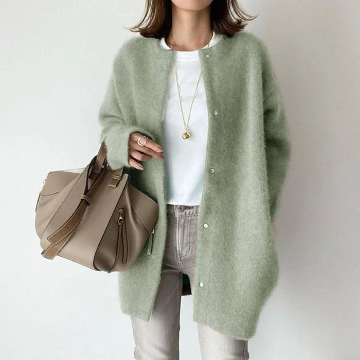 Oversized knit cardigan in soft sage green adding a fresh cozy touch to minimalist casual outfits