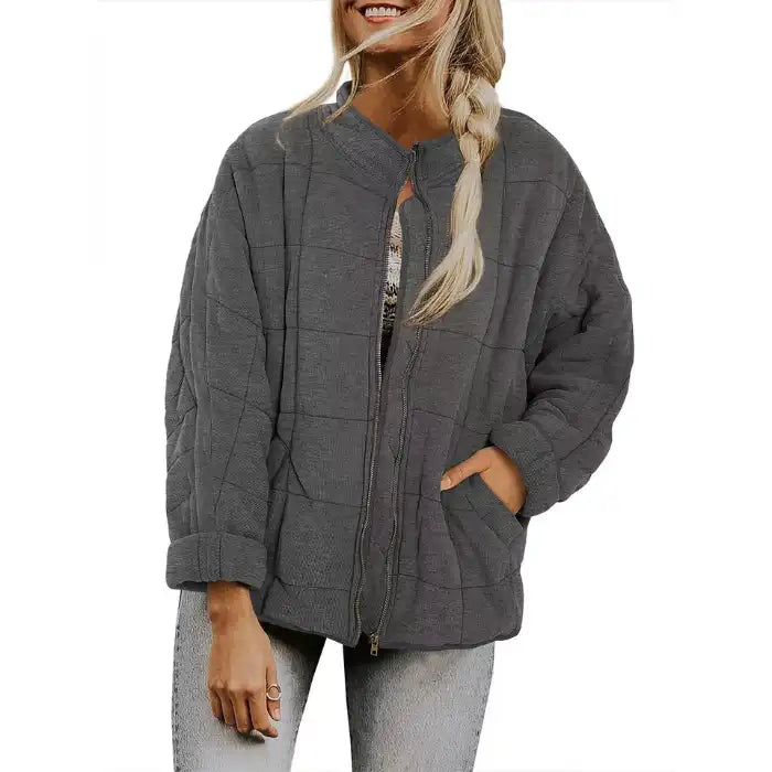  Oversized quilted zip jacket in charcoal grey with relaxed fit and side pockets, front view.