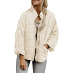 Oversized quilted zip jacket in cream color with square quilting pattern and relaxed fit, front view.